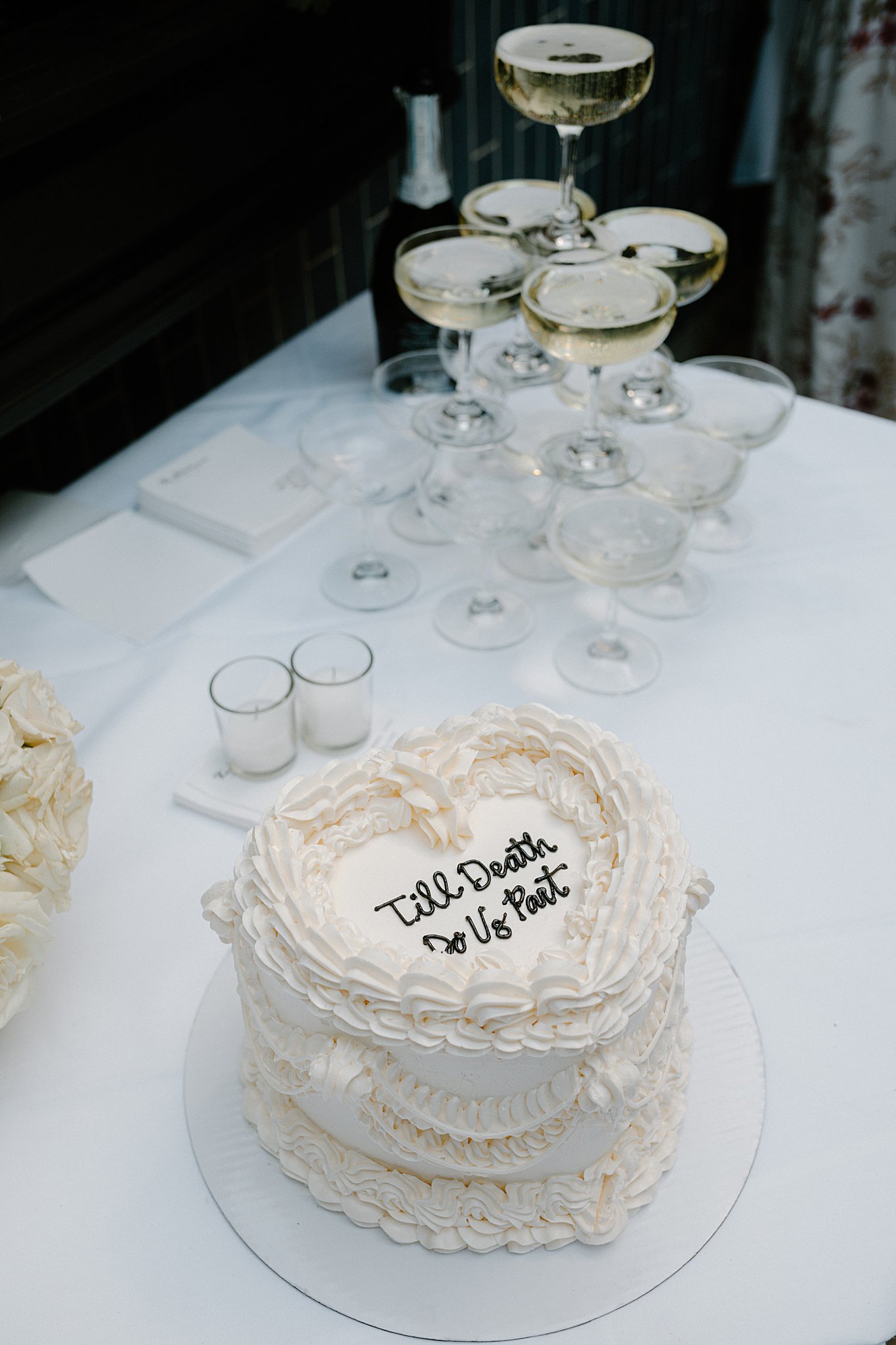heart shaped wedding cake sits next to champagne tower at Intimate Mia Francesca Wedding