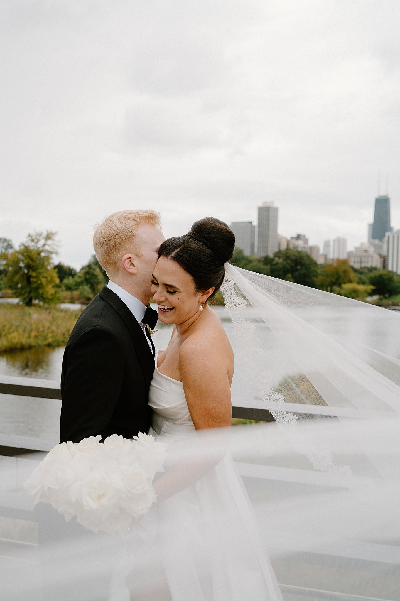 bride grins and groom kisses her cheek before downtown Chicago ceremony
