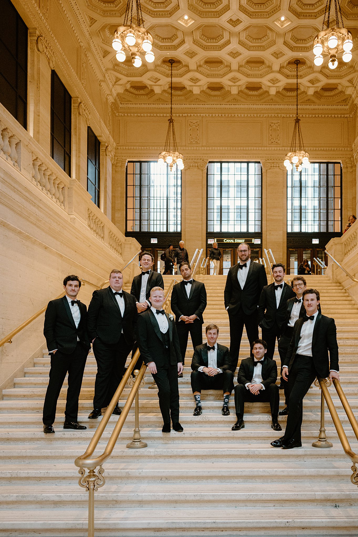 groomsmen gather on the ornate white steps before downtown Chicago ceremony