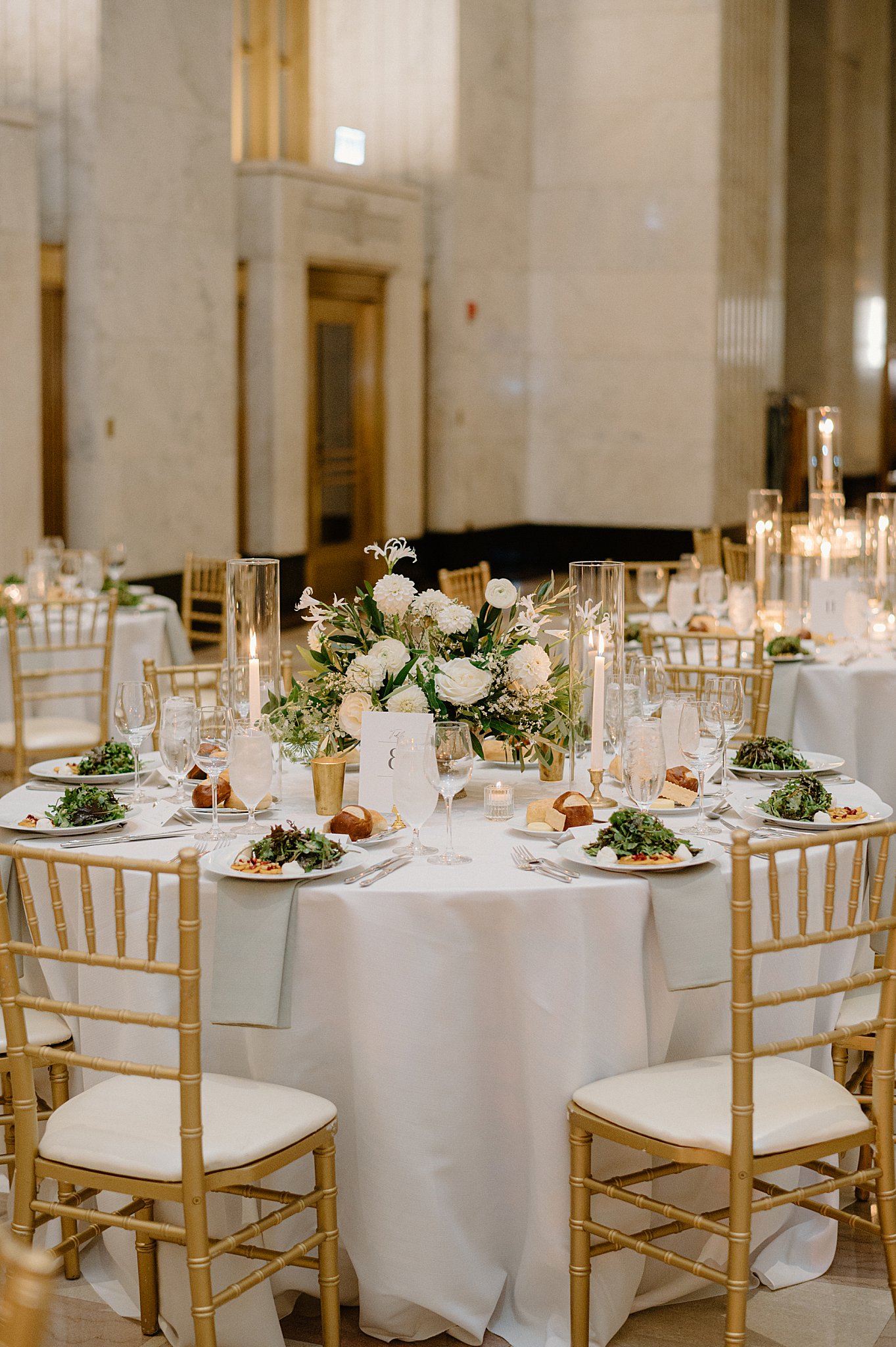 reception table set with white florals and gold chairs by Indigo Lace Collective