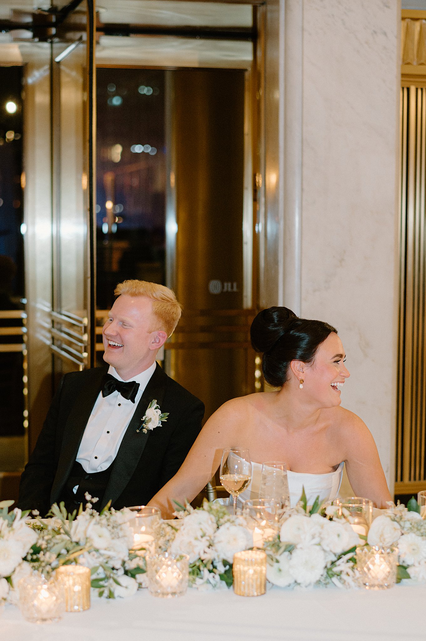 couple laughs and looks at guests during reception after downtown Chicago ceremony