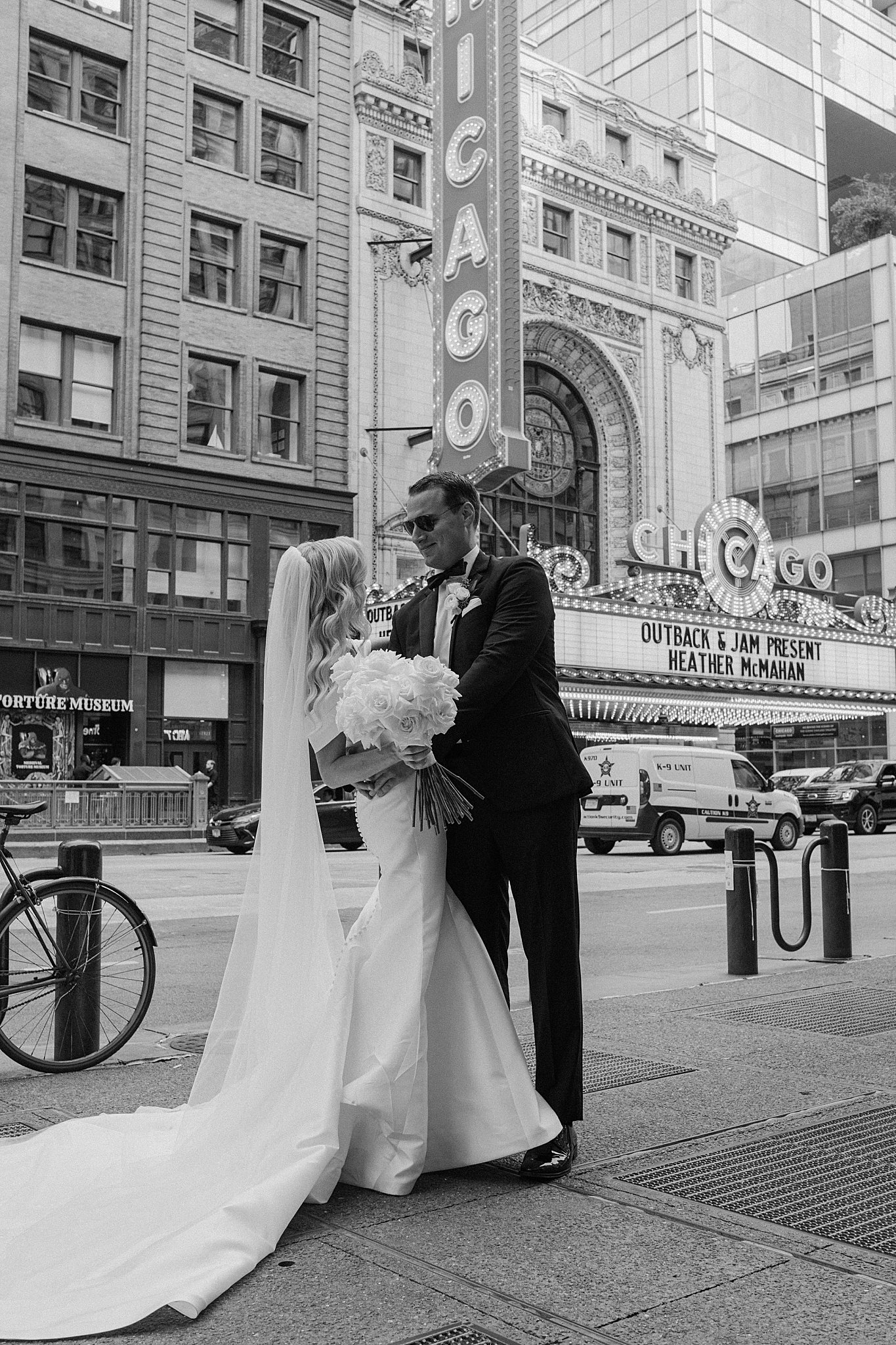bride and groom stand in front of Chicago theater before romantic Galleria Marchetti ceremony