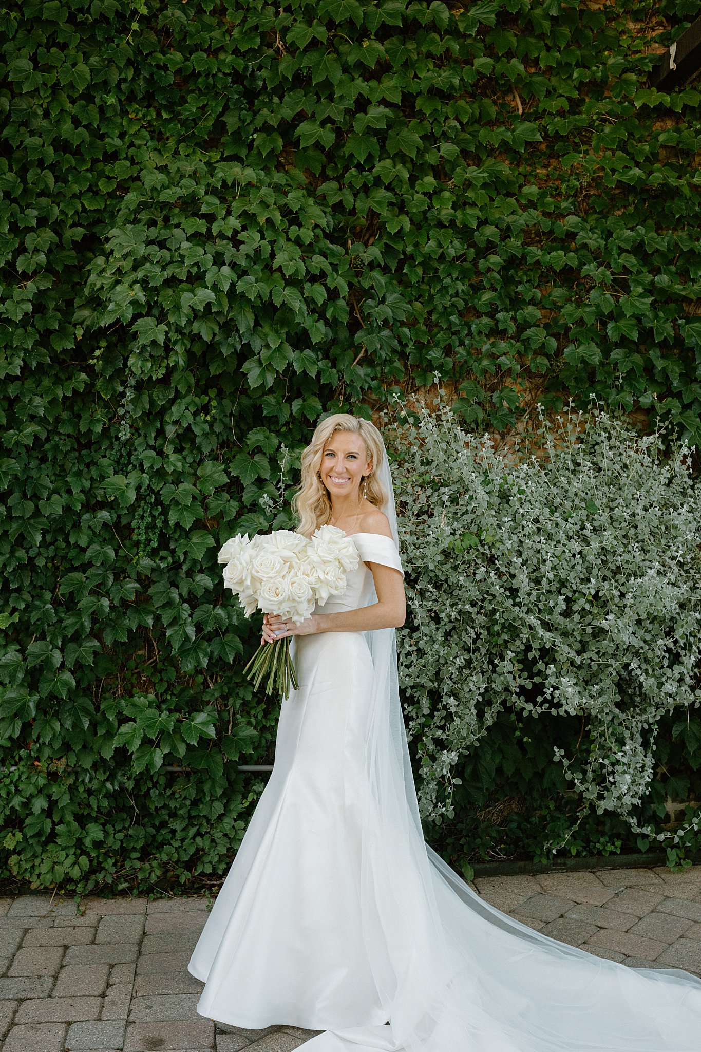 bride holds large white roses in her bouquet before her romantic Galleria Marchetti ceremony