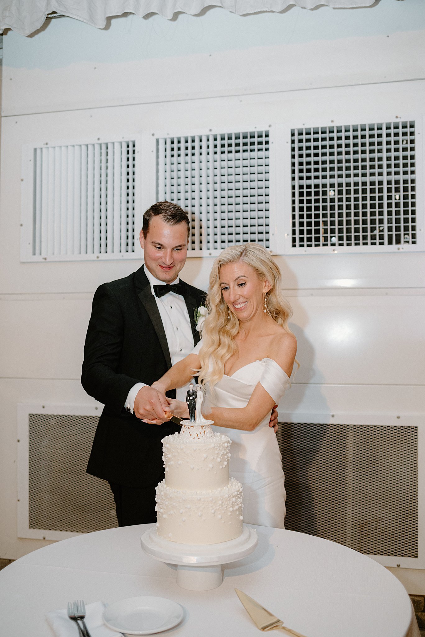 newlyweds cut their wedding cake after romantic Galleria Marchetti ceremony