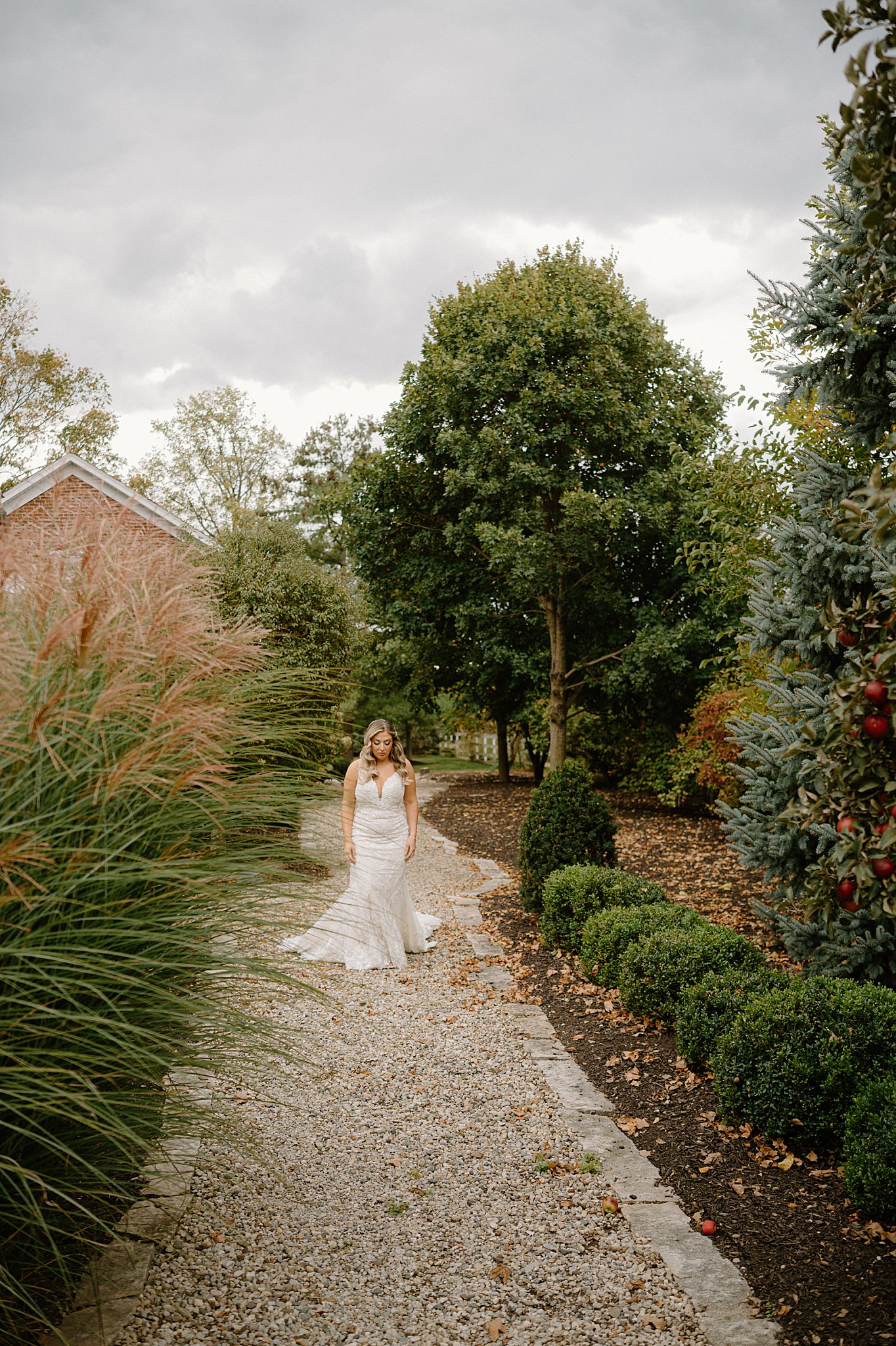 bride walks down path to meet groom for first look by Midwest wedding photographer