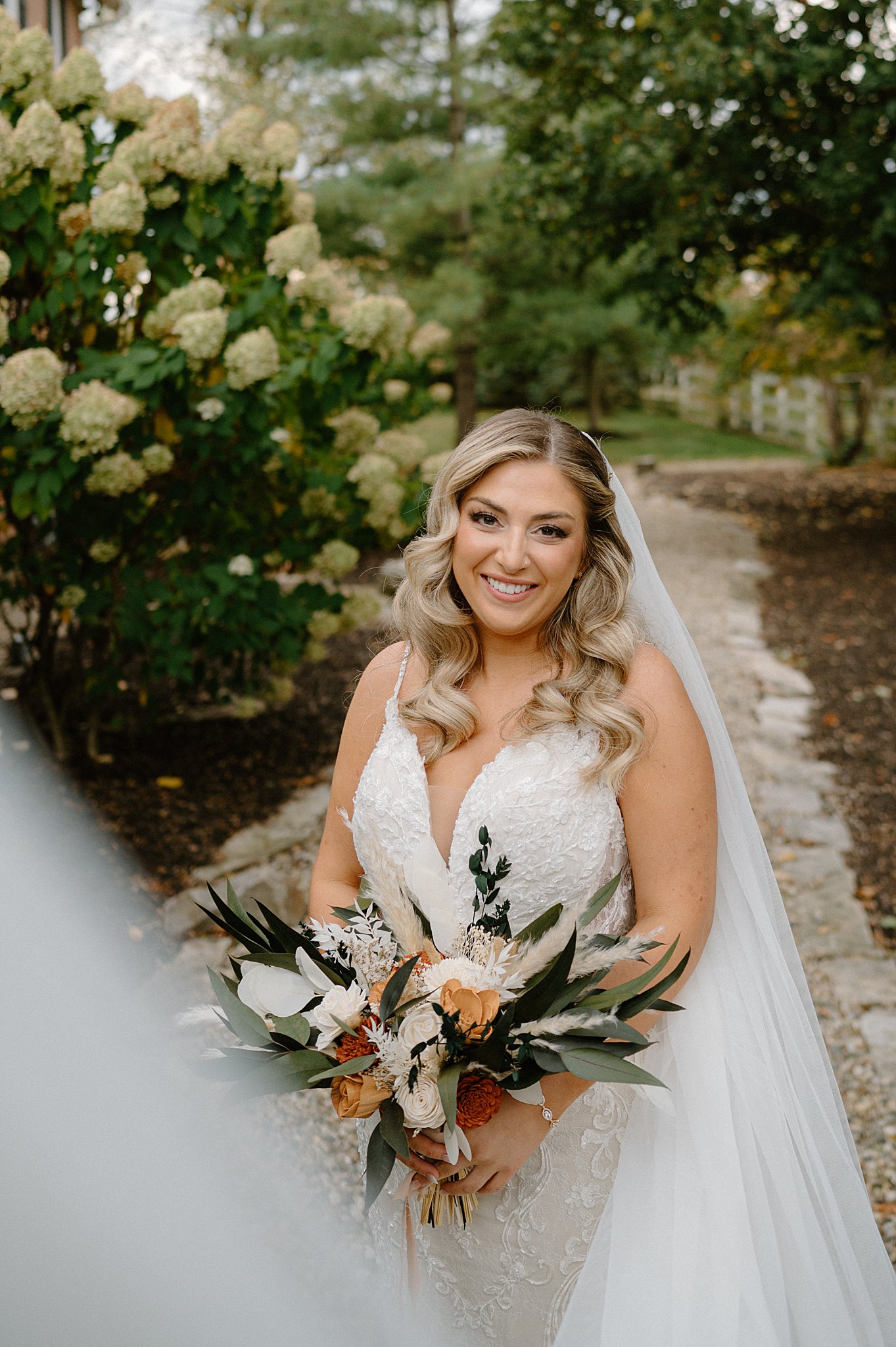 bride smiles holding her bouquet by Indigo Lace Collective